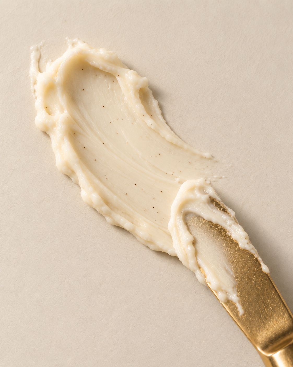 Sable Vanilla tallow balm spread across a cream surface with a gold knife