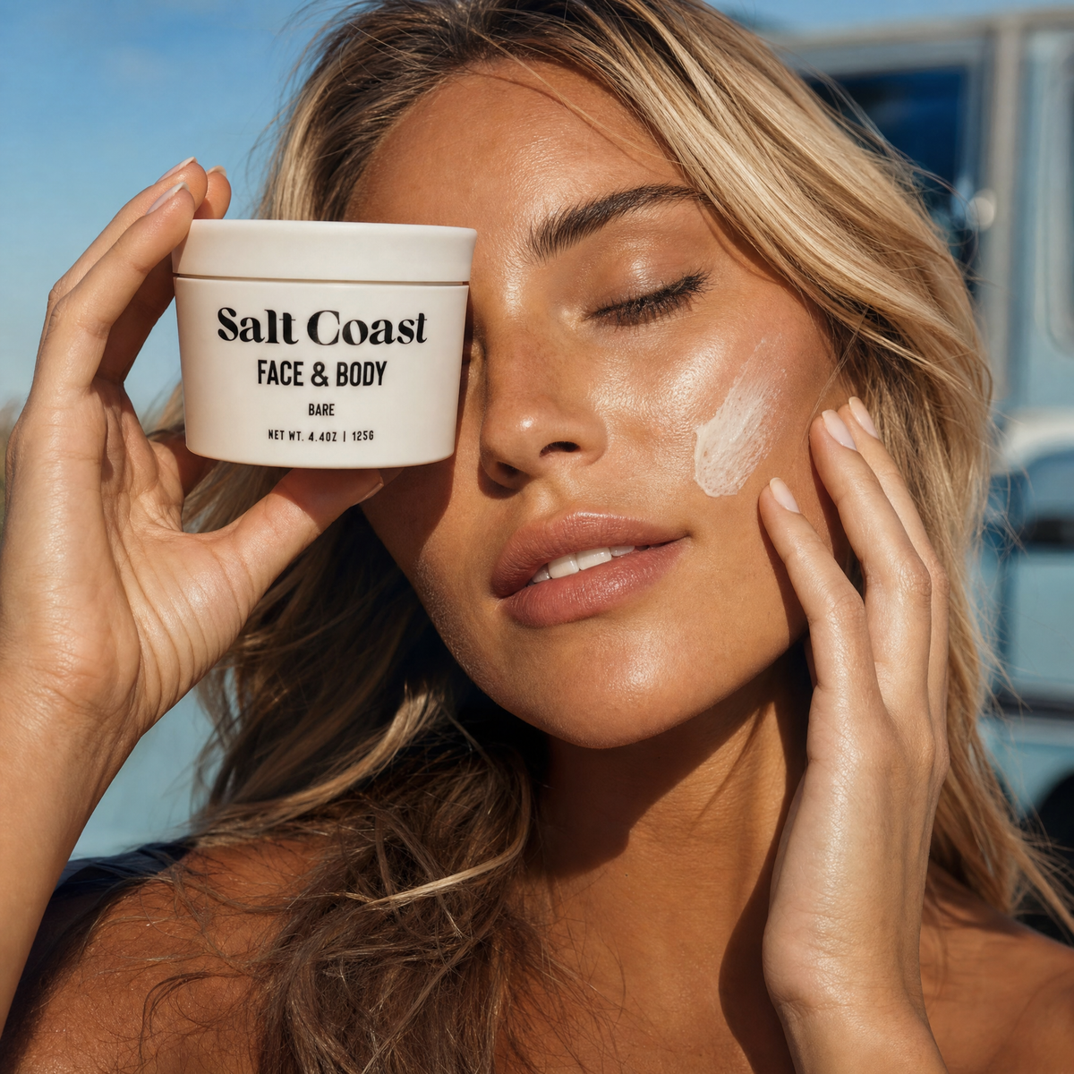 Hand resting on Salt Coast Bare and Sable Vanilla tallow balm jars