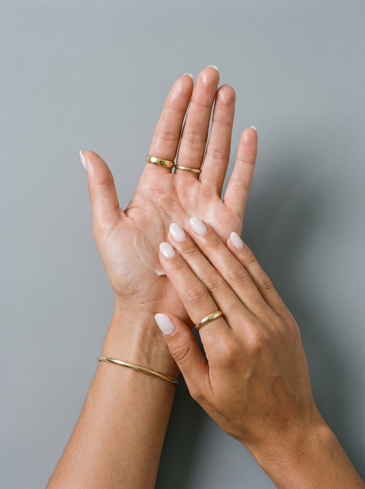 Hands warming tallow balm between the palms before applying